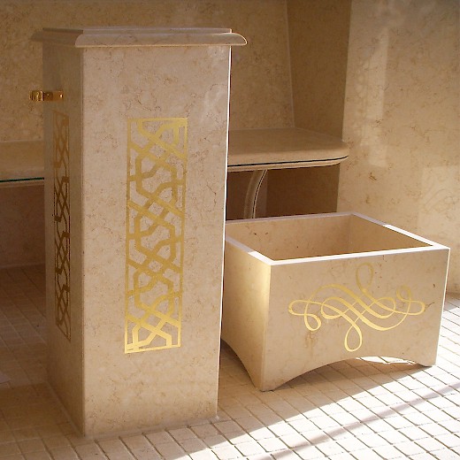Die Fußwaschbecken vor der Sauna sind aus Travertin und mit Gold-Ornamenten verziert