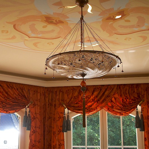 Die Decke mit Gold-Elementen und die Gardinen unterstützen im Esszimmer die märchenhafte Atmosphäre - besonders bei abendlicher Beleuchtung