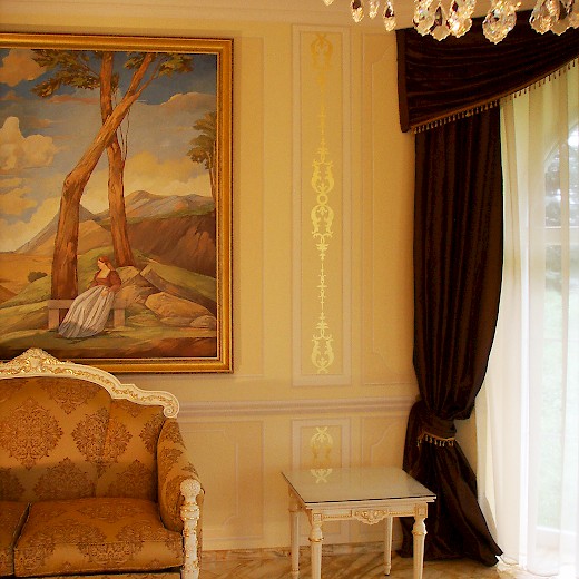 Das barocke Gold-Ornat im gemalten Stuckrahmen verbindet Einrichtung und Raum und gibt ihm besonderen Glanz