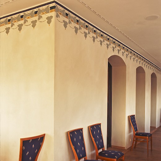 Die Wände im Restaurant haben wir mit stilisierten Weinranken gestaltet und die Stuhlbezüge mit einem zarten Blattmuster