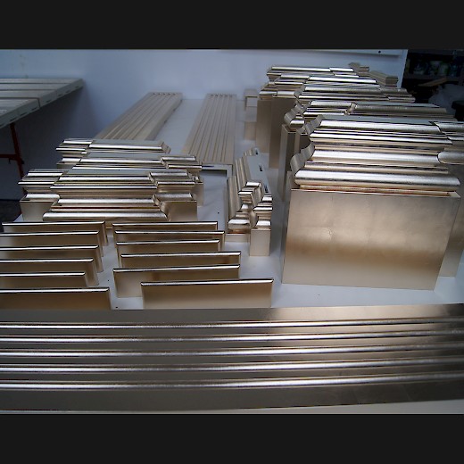 Hier sehen Sie Einzelteile von Säulen für eine Wandverkleidung in Rosenobel-Doppelgold mit Platin
